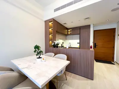 a kitchen and dining room with a table and chairs at Stylish 1-Bedroom Retreat in Prime Gardens , Arjan in Dubai