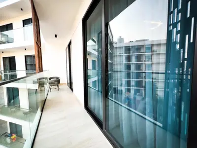 a balcony with glass walls and a view of a building at Stylish 1-Bedroom Retreat in Prime Gardens , Arjan in Dubai