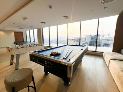 a room with a pool table and a couch at Stylish 1-Bedroom Retreat in Prime Gardens , Arjan in Dubai