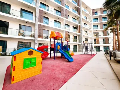 a playground in front of a apartment building at Stylish 1-Bedroom Retreat in Prime Gardens , Arjan in Dubai