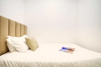 a bed with white sheets and a book on it at Dubai dream villa Emaar in Dubai