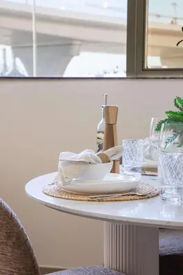 a white table with plates and glasses on it at Frank Porter - Zen Tower in Dubai