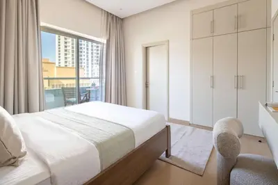 a bedroom with a bed and a desk and a window at Frank Porter - Zen Tower in Dubai