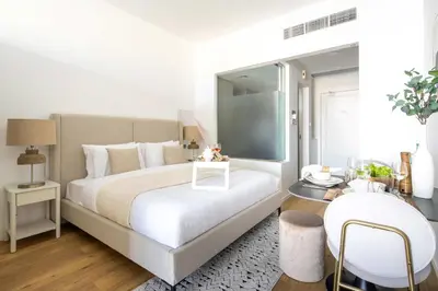 a bedroom with a large white bed and a table at Frank Porter - Palm Views East in Dubai