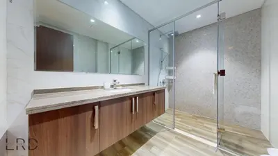 a bathroom with a sink and a glass shower at Stunning 2-Bed Apartment with Canal View in Dubai