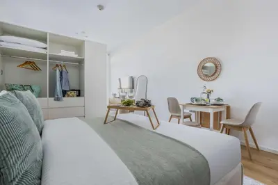 a bedroom with a bed and a table with chairs at Frank Porter - Palm Views East in Dubai