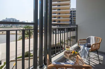 a balcony with two chairs and a basket of fruit at Frank Porter - Legacy by Sunrise in Dubai