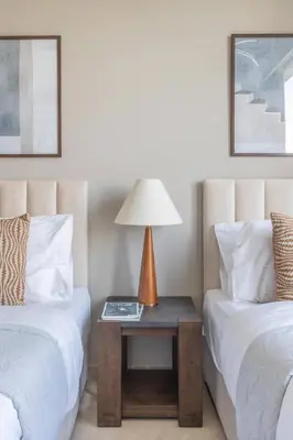 a bedroom with two beds and a table with a lamp at Frank Porter - Grande Residence in Dubai