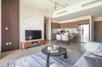 a living room with a couch and a tv and a table at Frank Porter - Grande Residence in Dubai