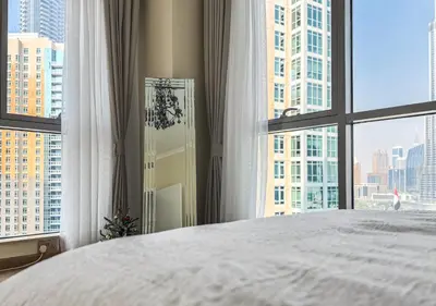 a bedroom with a white bed and a large window at DreamShoma-3BR Super Luxurious The Residence 5 Downtown in Dubai