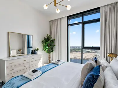 a bedroom with a large bed and a large window at Serene 2BDR with Beach Scenery In Creek Edge- Creek Harbour in Dubai