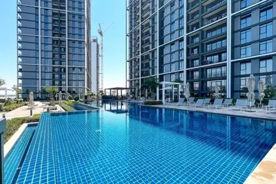 a swimming pool with tall buildings in the background at Serene 2BDR with Beach Scenery In Creek Edge- Creek Harbour in Dubai