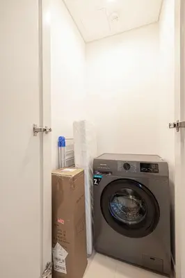 a washing machine in a room with a box at Downtown Dreams Burj Khalifa View with Dubai Mall, Pool & Free Parking in Dubai