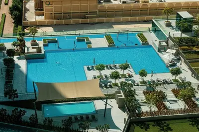 an overhead view of a large swimming pool at Downtown Dreams Burj Khalifa View with Dubai Mall, Pool & Free Parking in Dubai