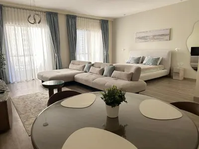 a living room with a couch and a table at Rimal 2 JBR Studio 70m2 beach, gym, pool in Dubai