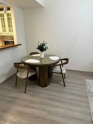 a table and chairs with a vase of flowers on it at Rimal 2 JBR Studio 70m2 beach, gym, pool in Dubai