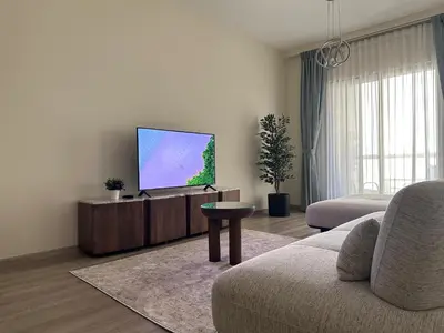 a living room with a flat screen tv on a cabinet at Rimal 2 JBR Studio 70m2 beach, gym, pool in Dubai