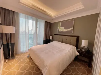 a bedroom with a bed and a large window at Apt Dubai Downtown in Dubai