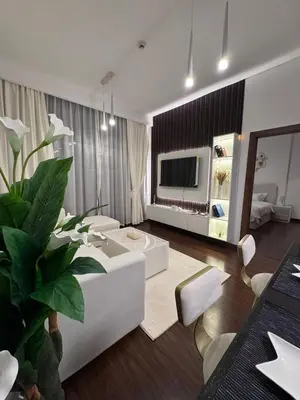 a living room with a white couch and a tv at Live a life of luxury in Dubai