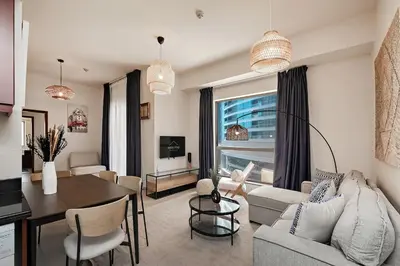 a living room with a table and a dining room at Cozy 1BR apartment in JBR in Dubai