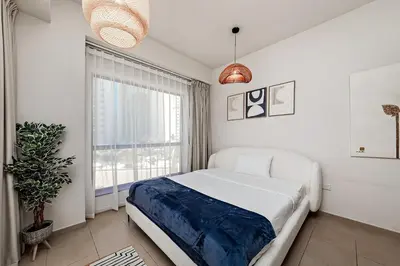 a bedroom with a large bed and a window at Cozy 1BR apartment in JBR in Dubai