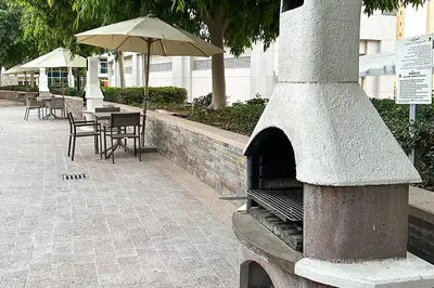 an outdoor oven with a table and an umbrella at Chic 1 Bedroom Apartment in Dubai Marina, Marina View, Near JBR in Dubai