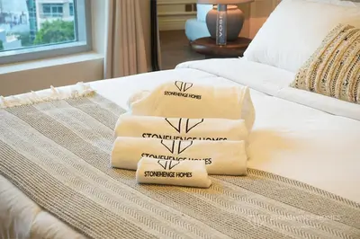 a pile of towels sitting on top of a bed at Chic 1 Bedroom Apartment in Dubai Marina, Marina View, Near JBR in Dubai