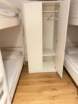 a room with white bunk beds and a wooden floor at JBR bed-space in Dubai