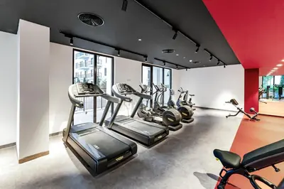 a gym with several tread machines in a row at Luxury lifestyle at La Sirene Port de la Mer Jumeirah 1 in Dubai