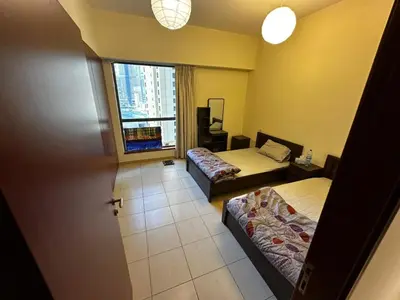 a hotel room with two beds and a window at Spacious bedroom with easy access to the tram and beach, located near JBR Walk in Dubai
