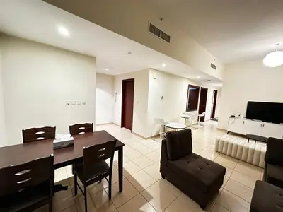 a dining room and living room with a table and chairs at Spacious bedroom with easy access to the tram and beach, located near JBR Walk in Dubai