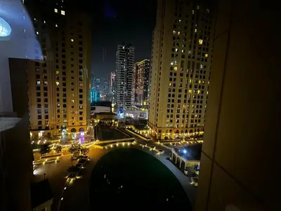 a view of a city at night with traffic at Spacious bedroom with easy access to the tram and beach, located near JBR Walk in Dubai