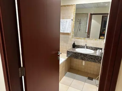 a bathroom with a sink and a mirror at Spacious bedroom with easy access to the tram and beach, located near JBR Walk in Dubai