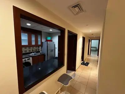 a room with a kitchen with a refrigerator and a table at Spacious bedroom with easy access to the tram and beach, located near JBR Walk in Dubai