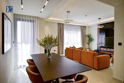 a living room with a table and a couch at Luxury Escapes - Luxurious 2-Bedroom Apartment with Stunning Lake Views in JBR in Dubai