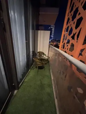 a balcony with a table and chairs on a building at Brand New Apartment IN JVC in Dubai