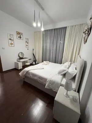 a bedroom with a large bed and a table at Brand New Apartment IN JVC in Dubai