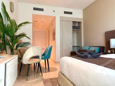 a bedroom with a bed and a table and chairs at Studio Apartment in Seven Palm with Beach Access in Dubai