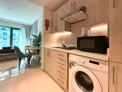 a kitchen with a washer and dryer in a room at Studio Apartment in Seven Palm with Beach Access in Dubai
