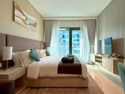 a bedroom with a large bed and a television at Studio Apartment in Seven Palm with Beach Access in Dubai