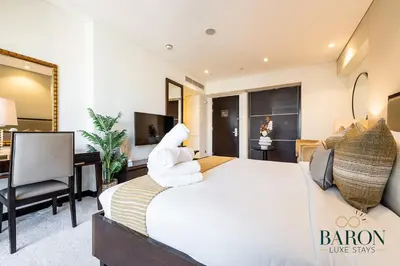 a bedroom with a large bed with white towels on it at The Signature in Dubai