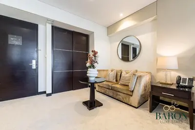 a living room with a couch and a table with a mirror at The Signature in Dubai