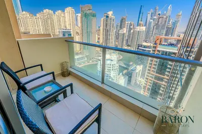 a balcony with two chairs and a view of a city at The Signature in Dubai