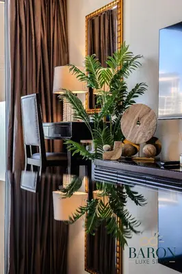a desk with a mirror and a plant on it at The Signature in Dubai
