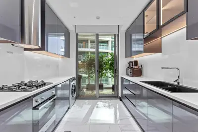 a white kitchen with a sink and a stove at Lush Living with Jacuzzi and Burj Khalifa View in Dubai