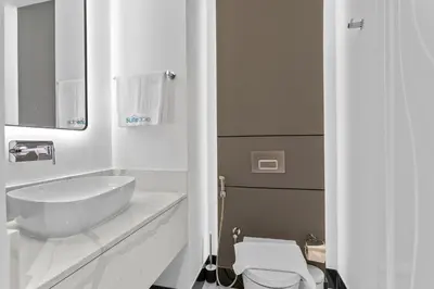 a white bathroom with a sink and a toilet at Lush Living with Jacuzzi and Burj Khalifa View in Dubai
