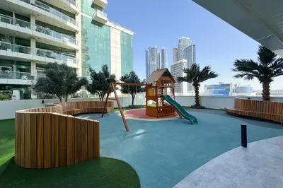 a playground with a slide and a swing at Lush Living with Jacuzzi and Burj Khalifa View in Dubai