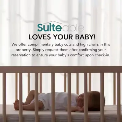 a baby laying on a bed in a crib at Luxury 1 Bedroom in the Heart of Famous Downtown in Dubai