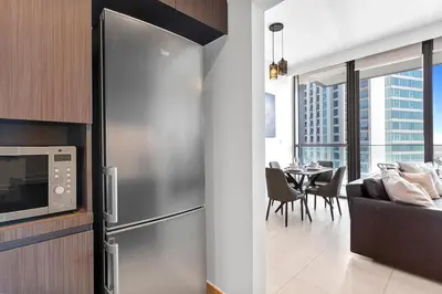 a kitchen with a stainless steel refrigerator and a dining room at Luxury 1 Bedroom in the Heart of Famous Downtown in Dubai