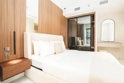 a bedroom with a white bed and a mirror at Marina Sea View,Elegant and Spacious - High Floor in Dubai